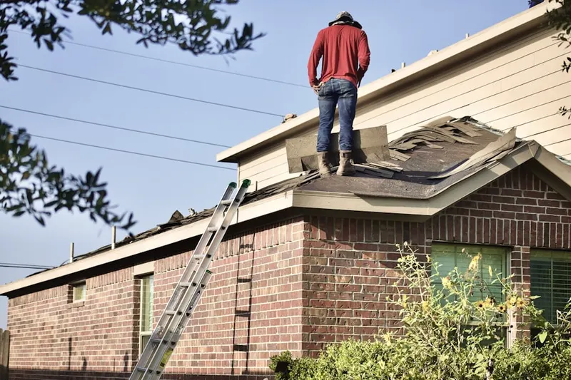 Professional roofer working on a residential roof in Willmore City